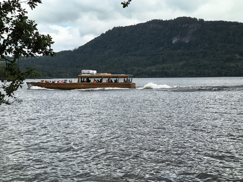 The launch on Derwent Water passes from right to left on its way to Hawes End